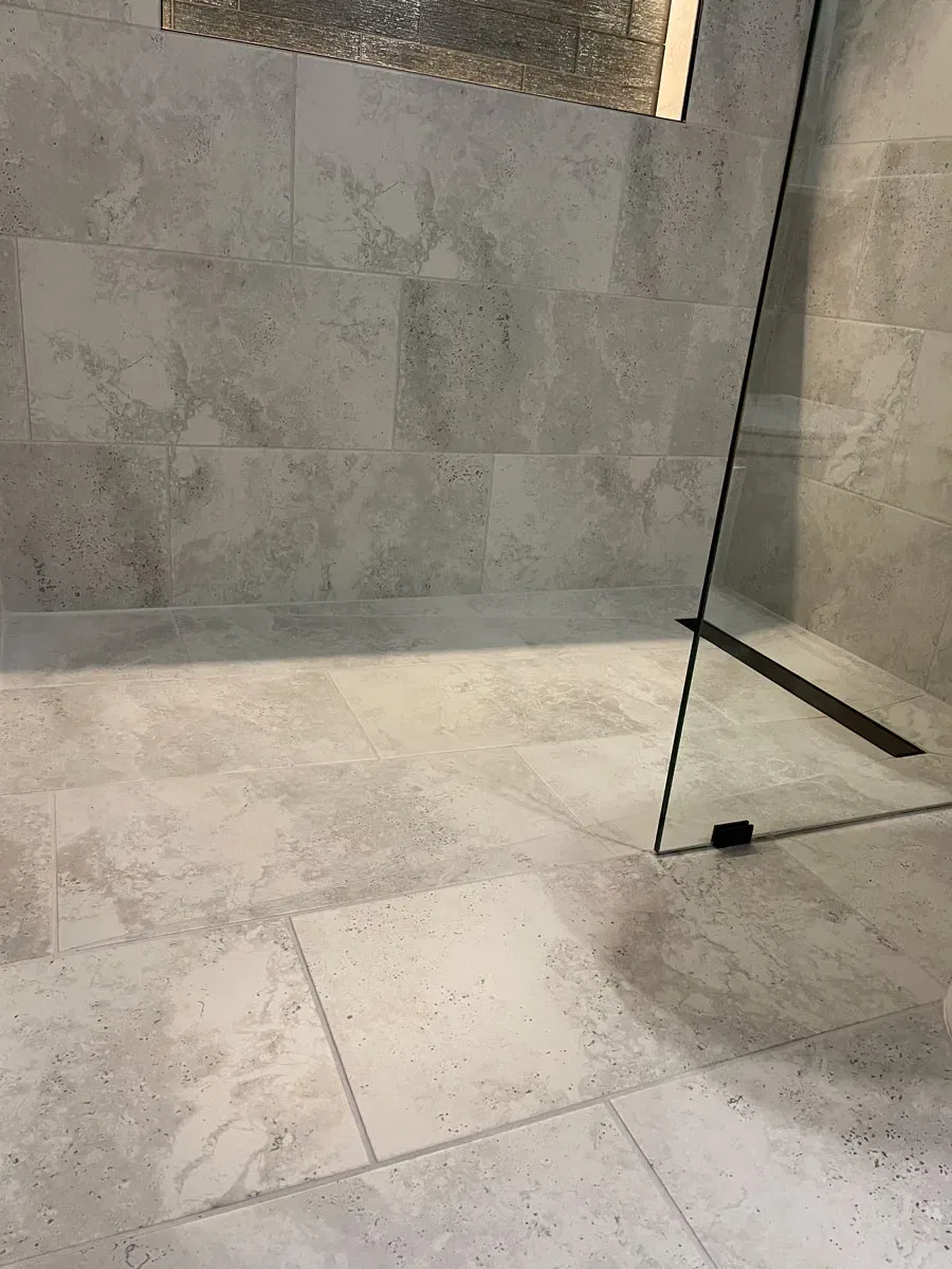 Modern bathroom with marble tiles and glass shower door